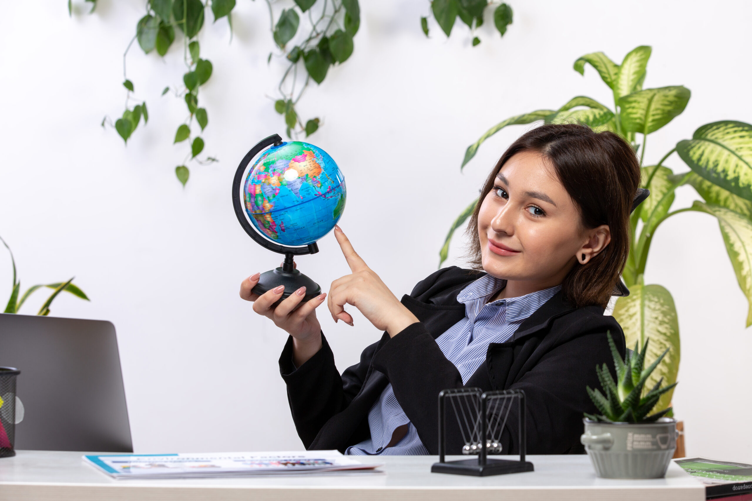 front-view-beautiful-young-businesswoman-black-jacket-blue-shirt-observing-little-globe-smiling-front-table-business-job-office (1)